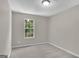 Bright bedroom featuring neutral walls, carpet flooring, and a window view of lush greenery at 1372 Hollenbeck Ln, Riverdale, GA 30296