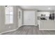 Open-concept living space with gray laminate floors, access to kitchen and backyard view at 1372 Hollenbeck Ln, Riverdale, GA 30296