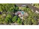 Drone eye view of an estate with a unique roof, a pool, and mature trees surrounding the property at 8655 Shoreline Dr, Jonesboro, GA 30236