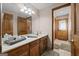 Bathroom featuring wood cabinets, a large mirror, and a tile floor, complete with a doorway at 8655 Shoreline Dr, Jonesboro, GA 30236