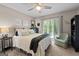 Bright bedroom featuring a large window, ceiling fan, and cozy chair creating a relaxing atmosphere at 8655 Shoreline Dr, Jonesboro, GA 30236