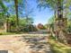 Long driveway with stone entrance, iron gate, mature trees and landscaping leads to a private and inviting property at 8655 Shoreline Dr, Jonesboro, GA 30236