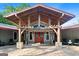 Inviting entrance featuring a porte-cochere with exposed wooden beams, a red door, and stone pillars at 8655 Shoreline Dr, Jonesboro, GA 30236