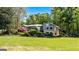 Spacious backyard with lush lawn and colorful gardens enhancing this lakefront property at 8655 Shoreline Dr, Jonesboro, GA 30236