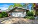 Attached two-car garage with a stone paver driveway, lush greenery, and charming landscaping, creating an inviting curb appeal at 8655 Shoreline Dr, Jonesboro, GA 30236