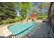 Sparkling pool surrounded by lush landscaping and a stone patio, perfect for outdoor enjoyment at 8655 Shoreline Dr, Jonesboro, GA 30236
