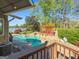 Backyard oasis with a sparkling pool, waterfall feature, stone patio, pergola, and verdant landscaping for relaxation and entertainment at 8655 Shoreline Dr, Jonesboro, GA 30236
