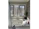 Bathroom featuring garden tub set below a window with a peaceful wooded view at 2467 Highway 138 Sw, Conyers, GA 30094