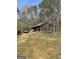 Exterior of property showing a weathered home with peeling siding, chain-link fence, and overgrown yard at 2467 Highway 138 Sw, Conyers, GA 30094