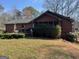 View of the rear exterior of the home showing a screened-in porch, wood siding, and mature landscaping at 2467 Highway 138 Sw, Conyers, GA 30094