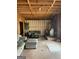 Partially finished living room featuring exposed ceiling beams, wood-burning stove, and concrete floor at 2467 Highway 138 Sw, Conyers, GA 30094