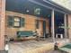 Inviting front porch with swing, rocking chair, and decorative hanging plant at 2467 Highway 138 Sw, Conyers, GA 30094