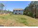 Wide shot of the backyard featuring a green lawn, and wooded perimeter on a sunny day at 101 Greenfield Ln, Grantville, GA 30220