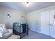 Neutral Bedroom showcases natural light, black crib, side chair, and modern sconces at 101 Greenfield Ln, Grantville, GA 30220