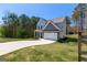 A lush, green lawn surrounds this two-story home with a spacious driveway on a sunny day at 101 Greenfield Ln, Grantville, GA 30220