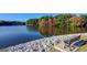 Scenic lake view with seating on rocky bank and colorful trees in the background at 106 Gateway Pt, Peachtree City, GA 30269