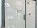 Close-up of a stylish walk-in shower with herringbone tile floor and a niche at 6887 Slate Stone Se Way # 3, Mableton, GA 30126