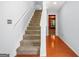 View of the staircase with carpeted steps, wood handrail, and an open view of the first floor at 6887 Slate Stone Se Way # 3, Mableton, GA 30126