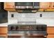 Close-up of a modern stovetop with stainless steel accents, set against a white tile backsplash and wood cabinets at 6887 Slate Stone Se Way # 3, Mableton, GA 30126