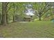 Expansive backyard with mature trees and a variety of outbuildings, including sheds and rustic structures at 2008 Highway 92 S, Fayetteville, GA 30215