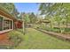 Backyard featuring lush greenery, a well-maintained fence, and partial view of the brick home's exterior at 2008 Highway 92 S, Fayetteville, GA 30215