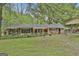 Brick home with well-maintained lawn, complemented by mature trees and a covered parking structure at 2008 Highway 92 S, Fayetteville, GA 30215