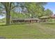 Expansive yard featuring a brick home with a covered parking area and mature trees at 2008 Highway 92 S, Fayetteville, GA 30215