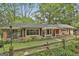 Charming brick home with a cozy front porch, landscaped yard, and a rustic wooden fence at 2008 Highway 92 S, Fayetteville, GA 30215
