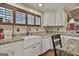 White kitchen featuring granite countertops, a farmhouse sink, and stainless appliances at 2008 Highway 92 S, Fayetteville, GA 30215