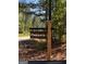 PINEGATE community sign alongside the road, nestled in a vibrant green forest at 0 Pinegate Way, Sharpsburg, GA 30277