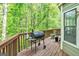 Wooden deck features a grill, wooden railing, and a view of lush trees at 675 Granby Hill Pl, Alpharetta, GA 30022