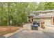 Townhouse with a brick facade, garage, driveway, and a tree-lined background at 675 Granby Hill Pl, Alpharetta, GA 30022