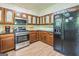 Fully equipped kitchen with wood cabinets, stainless steel microwave, and a black refrigerator at 675 Granby Hill Pl, Alpharetta, GA 30022