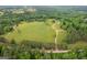 Scenic aerial view of farm property featuring lush greenery, a home, and farmland at 238 Indian Creek Rd, Locust Grove, GA 30248