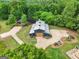 A captivating aerial view of the meticulously landscaped property, featuring a modern barn-style home and lush greenery at 238 Indian Creek Rd, Locust Grove, GA 30248