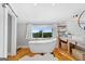 Bright bathroom featuring a modern soaking tub, wood floors, and large window with a scenic view at 238 Indian Creek Rd, Locust Grove, GA 30248