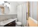 Well lit bathroom with a modern vanity, stylish mirror, and a shower with a white curtain at 238 Indian Creek Rd, Locust Grove, GA 30248