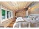 Bedroom featuring wood paneled walls and ceiling, natural light, and a comfortable bed at 238 Indian Creek Rd, Locust Grove, GA 30248