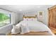 Bright bedroom with hardwood floors, white linens, and rustic wood accents at 238 Indian Creek Rd, Locust Grove, GA 30248