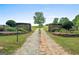 A long, winding gravel driveway leads to a private estate surrounded by lush greenery and mature trees at 238 Indian Creek Rd, Locust Grove, GA 30248