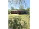 Expansive backyard featuring a well-maintained lawn, patio, sunroom, and exterior of a charming brick home at 6718 Delta Dr, Riverdale, GA 30274