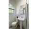 White bathroom featuring a pedestal sink, mirror and natural light from a large window at 6718 Delta Dr, Riverdale, GA 30274