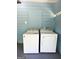 A well-equipped laundry room features a white washer and dryer and light blue wood paneling at 6718 Delta Dr, Riverdale, GA 30274