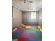 Spacious playroom with colorful floor tiles, brick accent wall, ceiling fans, and lots of natural light at 6718 Delta Dr, Riverdale, GA 30274