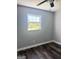 Empty bedroom featuring dark vinyl floors, modern ceiling fan, and natural light from a window at 6505 Allatoona Rd, Morrow, GA 30260