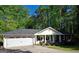 Charming single-story home with a two-car garage, front porch, and landscaped yard with mature trees in the background at 1898 Mornington Ln, Snellville, GA 30078