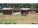 Back of the brick home featuring a small wooden deck and large backyard at 2215 Mount Carmel Rd, Hampton, GA 30228