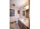 Bathroom vanity with sink and storage, toilet, and framed mirror and window at 2215 Mount Carmel Rd, Hampton, GA 30228
