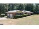 A brick home with an attached two-car garage, manicured hedges, and green shutters at 2215 Mount Carmel Rd, Hampton, GA 30228