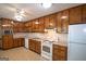 Functional kitchen featuring wood cabinets, white appliances, and ample counter space for food prep at 2215 Mount Carmel Rd, Hampton, GA 30228